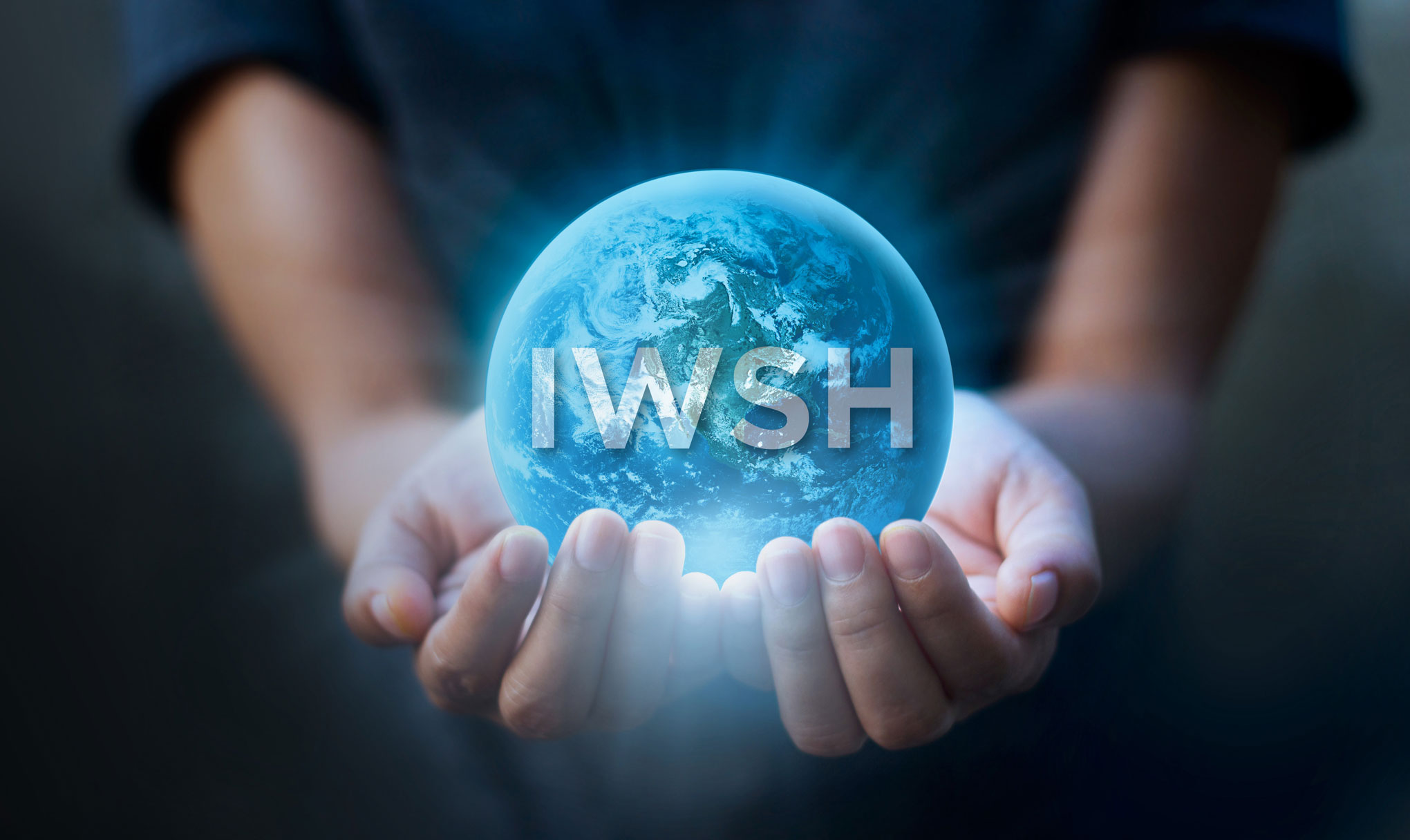 Hands cupping a glowing blue Earth with the letters IWSH overlaid on the globe