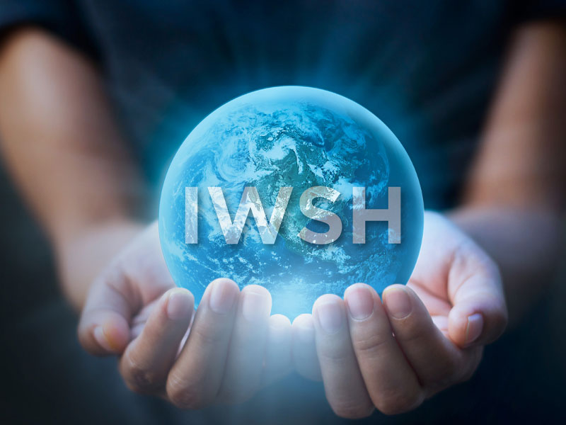 Hands cupping a glowing blue Earth with IWSH text across the globe