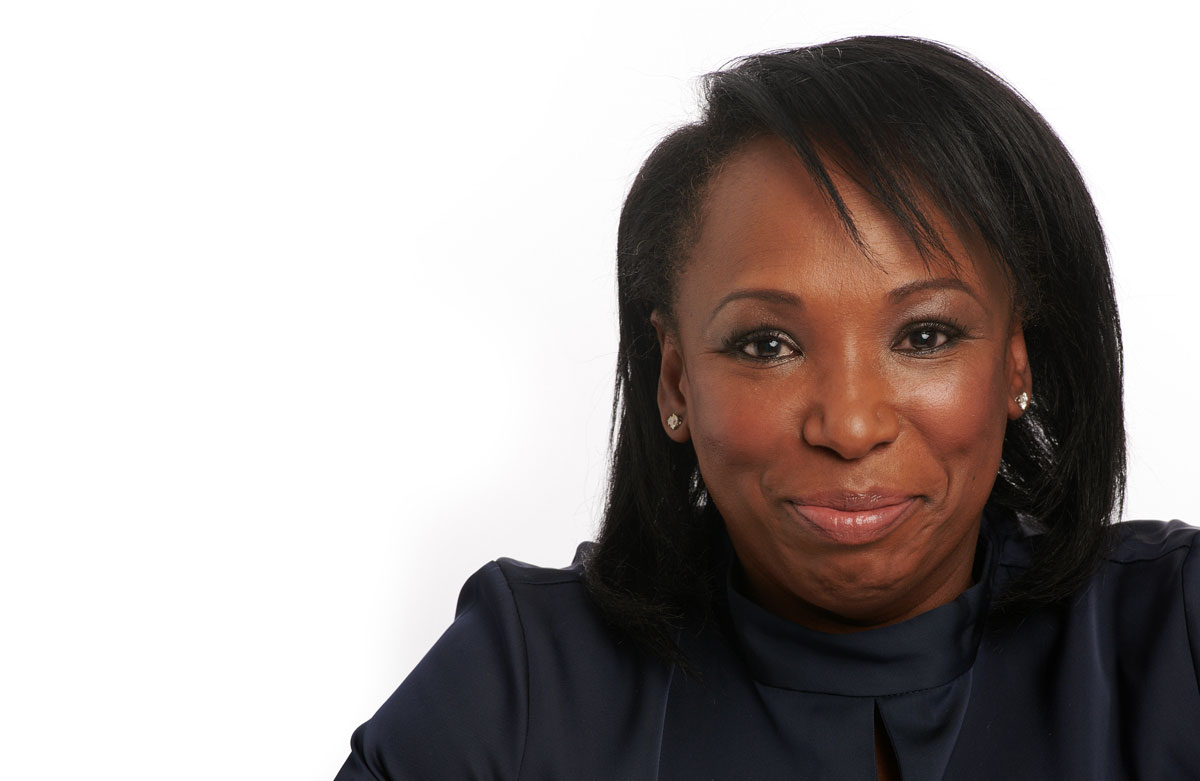 Smiling woman in a navy blouse against a white background (close-up portrait).